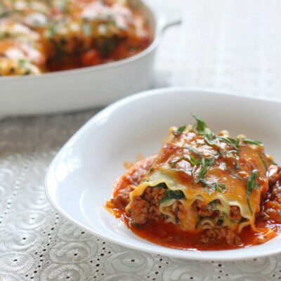 Lasagna roll-ups with crumbled sausage in tomato sauce