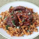 Osso buco with gremolata served over pasta