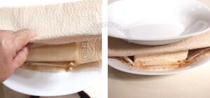 Pressing tofu between stacks of paper towels