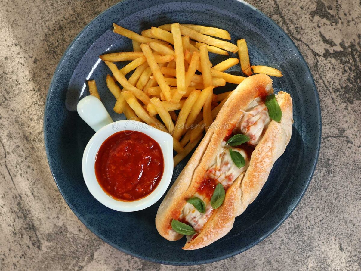 Meatballs sandwich (sub) with mozzarella served with fries and tomato sauce for dipping