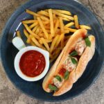 Meatballs sandwich (sub) with mozzarella served with fries and tomato sauce for dipping