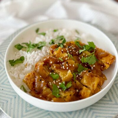 Lemongrass fried chicken garnished with sesame seeds and cilantro, and served over rice