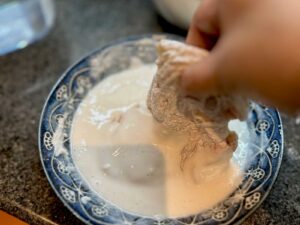 Dipping floured chicken fillet in batter