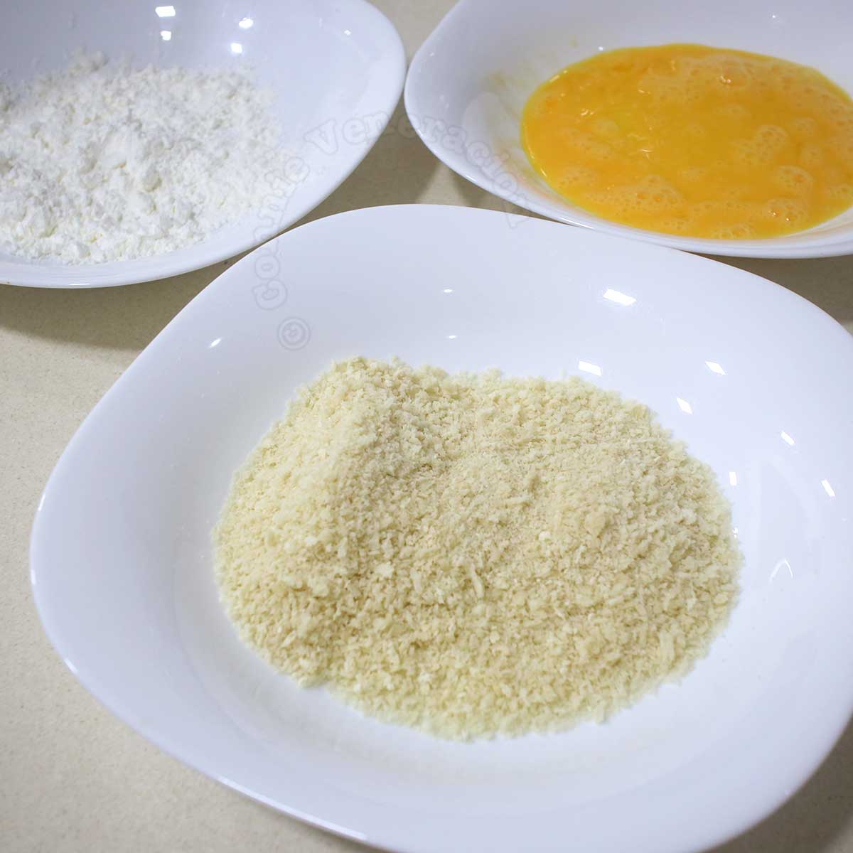 Potato starch, beaten egg and panko in shallow bowls