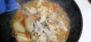 Pouring water over chicken and vegetables