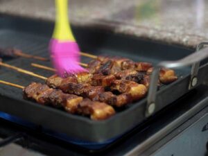 Basting skewered pork adobo with simple syrup