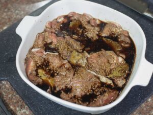 Marinating chicken thigh fillets in Filipino adobo sauce