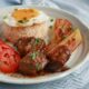 Slow cooker Filipino pork adobo with rice, egg, tomato slices and fried saba bananas