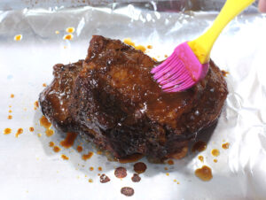 Brushing reduced bbq sauce on beef