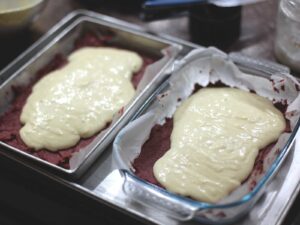 Red velvet brownie batter topped with cheesecake batter