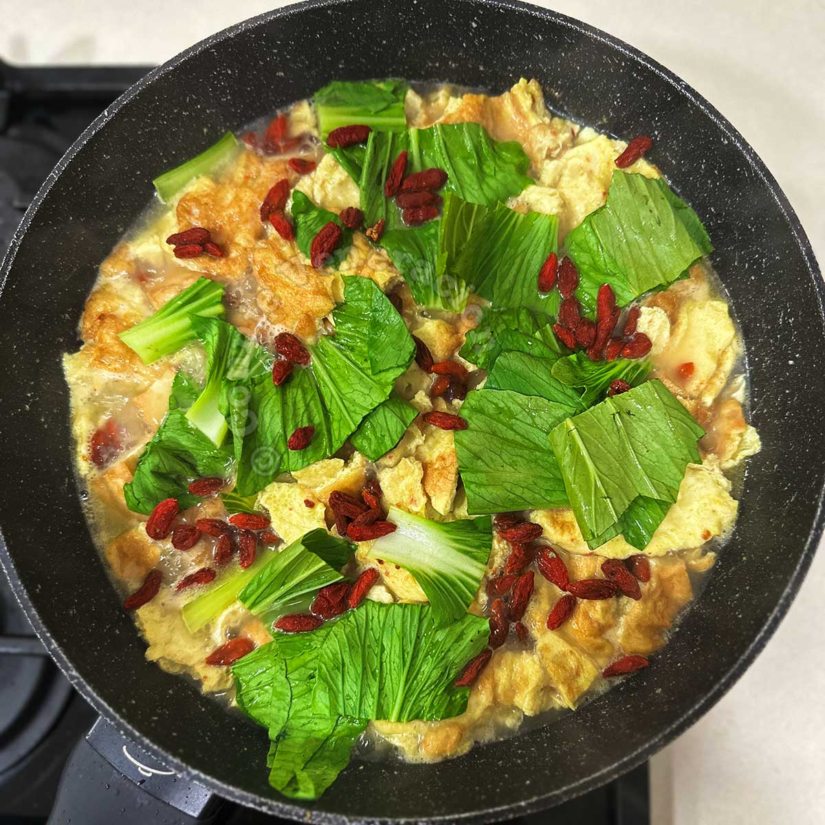 Tofu, egg and bok choy soup in wok