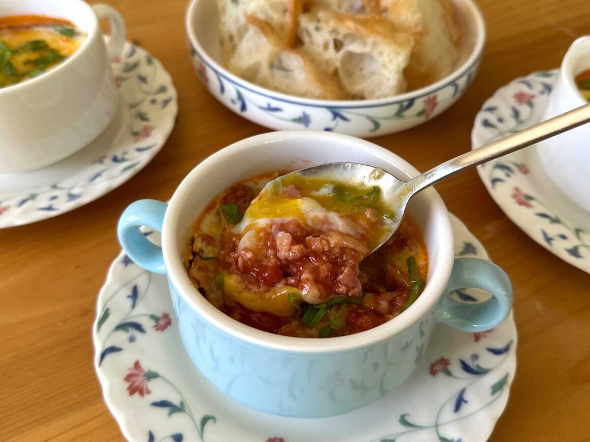 Eggs en cocotte with bacon and sausage meat ragu