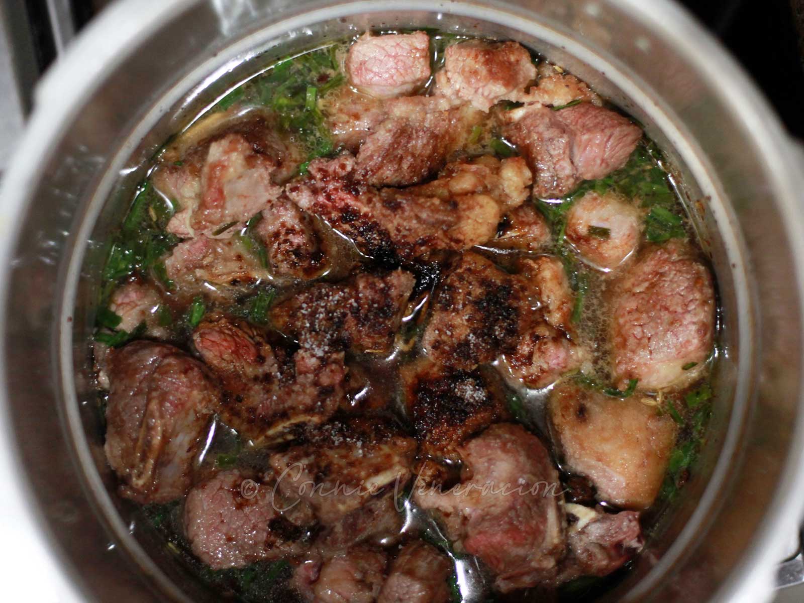 Adding spices to browned beef before pressure cooking