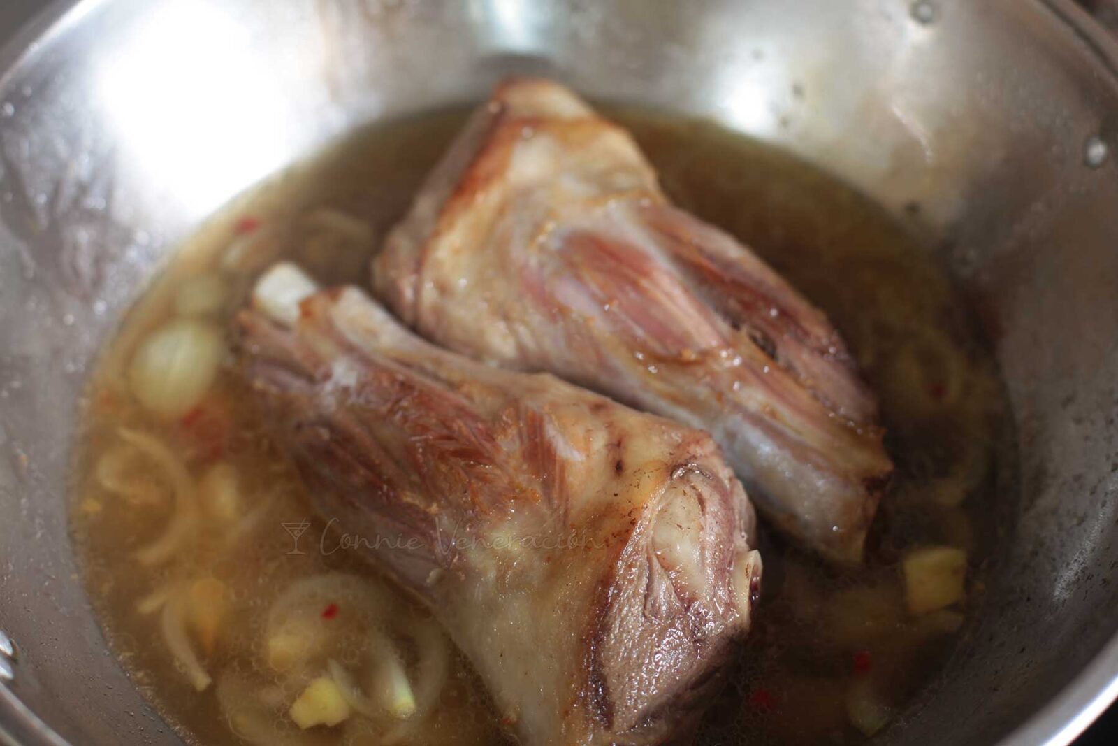 Braising lamb shanks with lemongrass, chilies, onion, garlic, ginger, fish sauce and sugar
