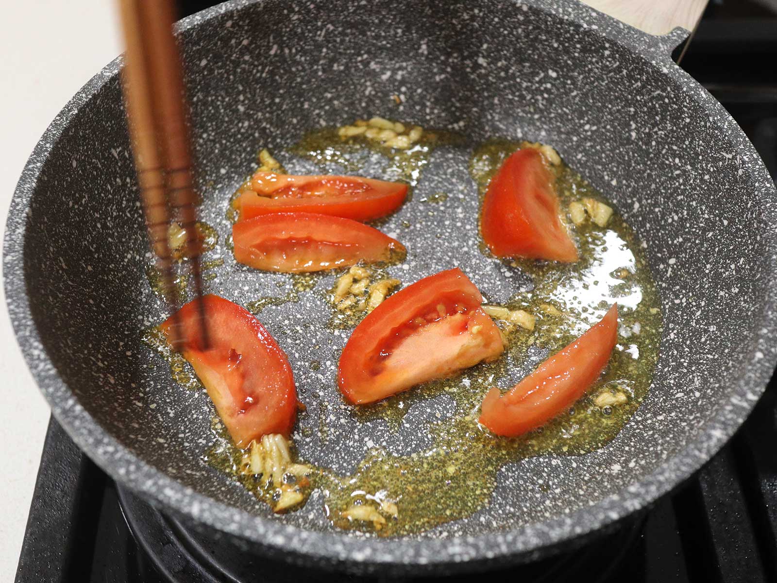 Sauteeing garlic and tomato in butter