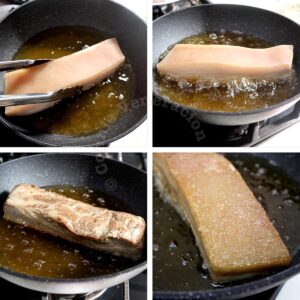 Browning a slab of pork belly in hot oil