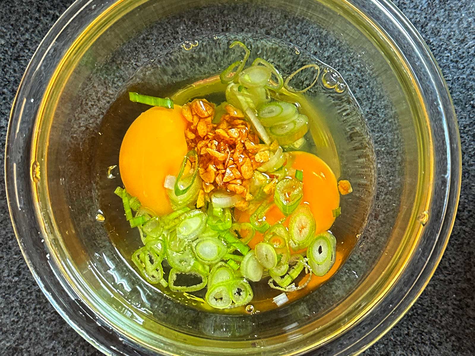 Eggs, scallions and fried garlic in mixing bowl