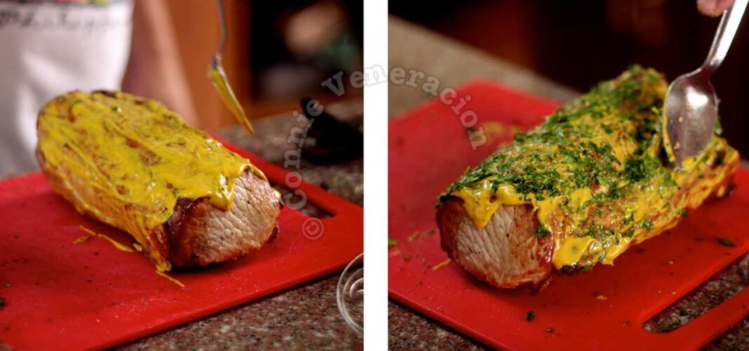 Spreading mustard on roast pork then pressing chopped thyme into the mustard