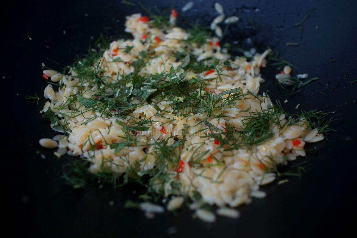 Tossing orzo with fresh dill and mint