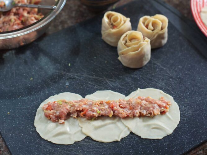 Pork filling spread across three wonton wrappers