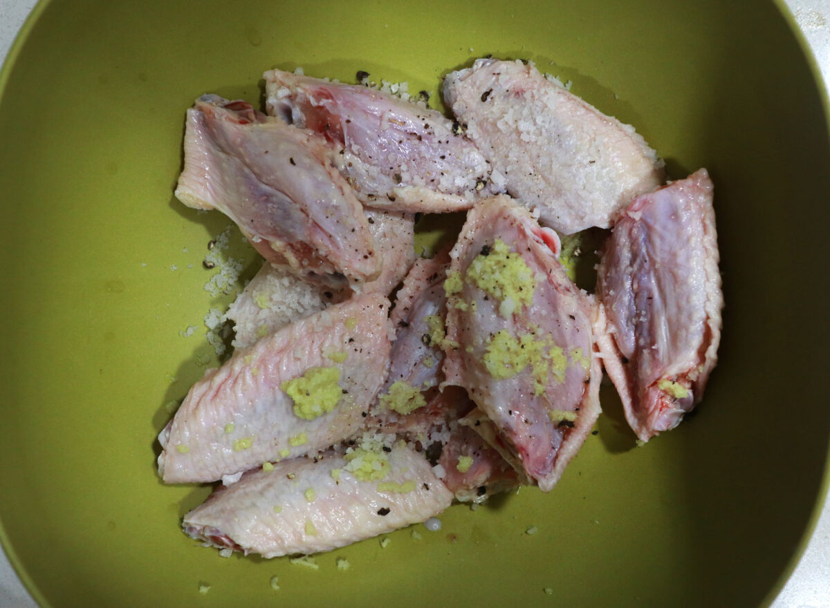 Marinating chicken wings in grated ginger, salt and chili flakes