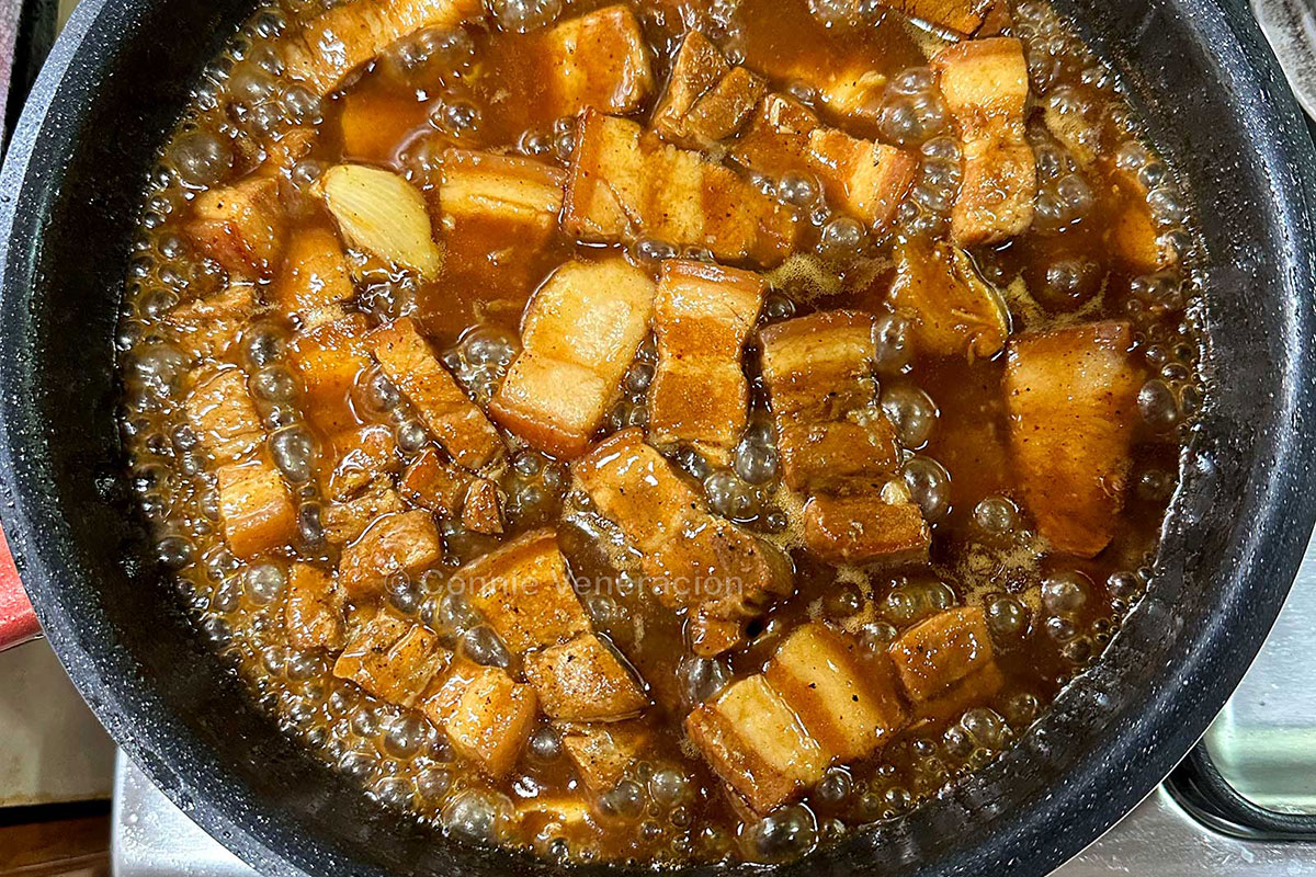 Pork adobo simmering on stovetop