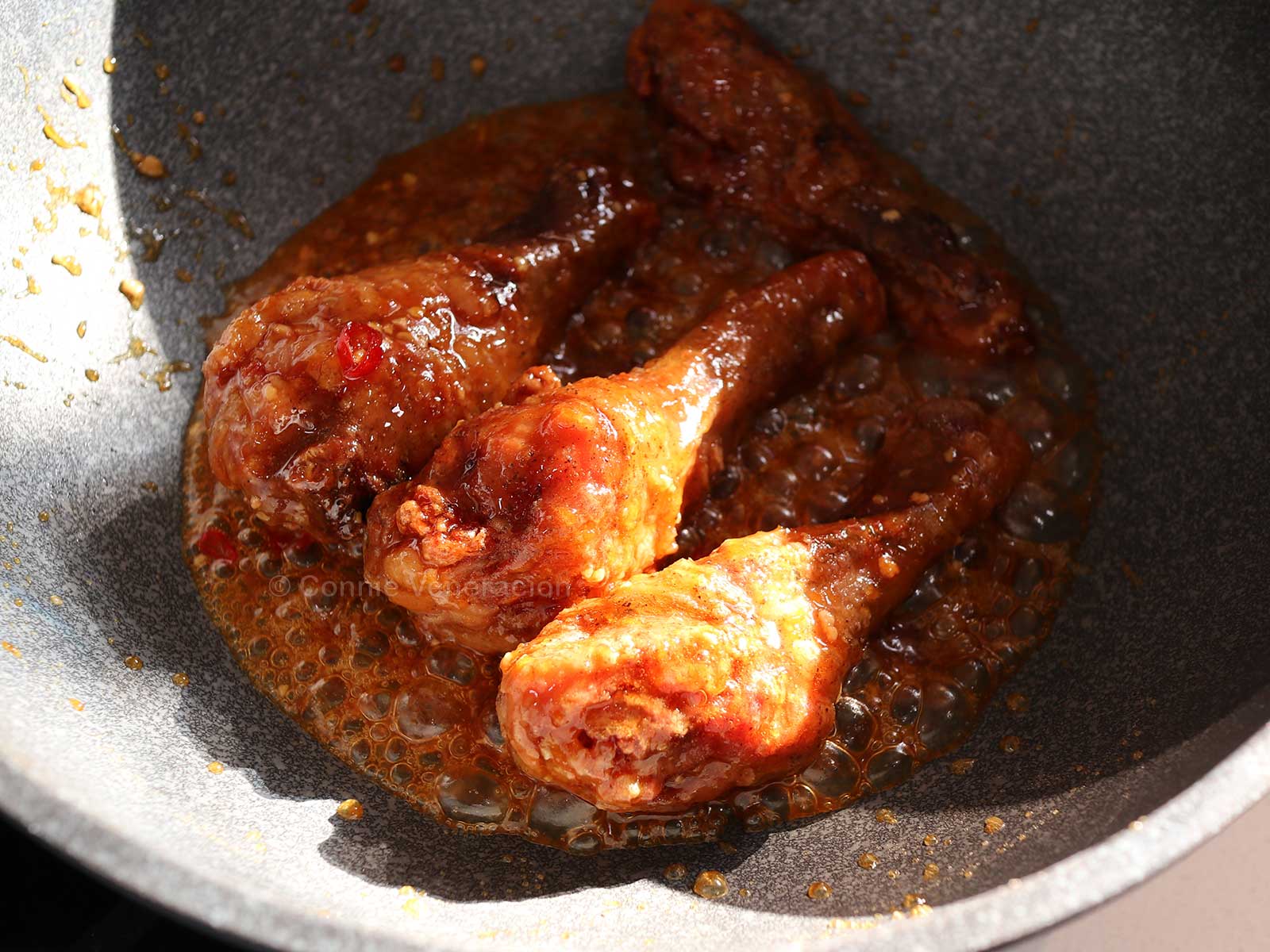 Tossing fried chicken in chili honey mustard glaze