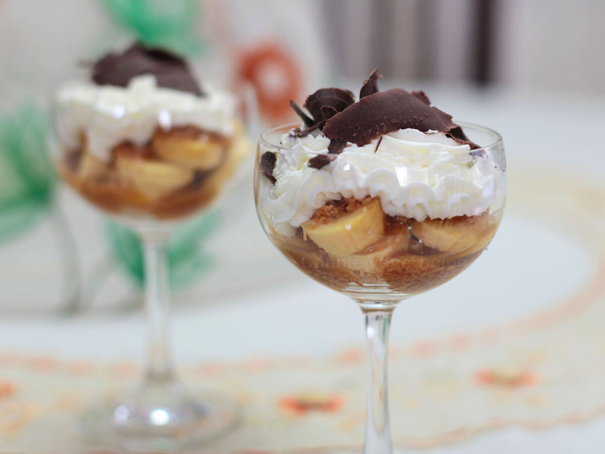 Banana slices, caramel, toasted coconut, whipped cream and shaved chocolate in glass