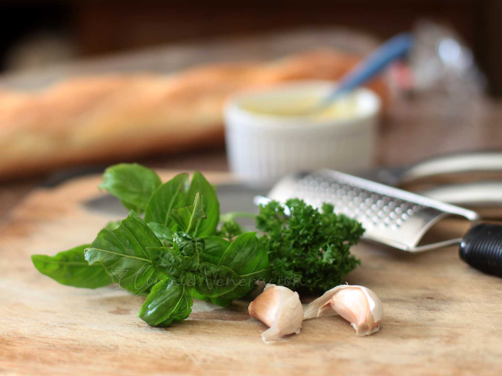 Basil, parsley and garlic cloves on bamboo chopping board
