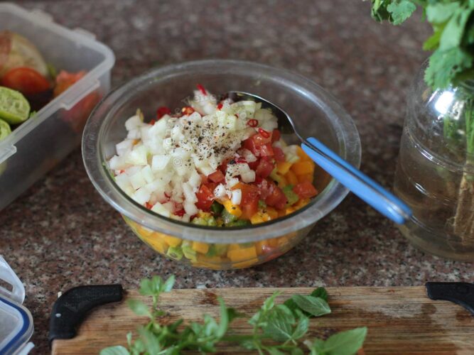 Chopped onion, tomato, mango and avocado in mixing bowl