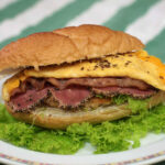Meat lover's sandwich with chicken schnitzel, bacon, pastrami and cheese omelette