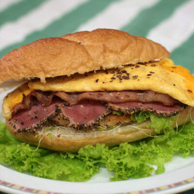 Meat lover's sandwich with chicken schnitzel, bacon, pastrami and cheese omelette