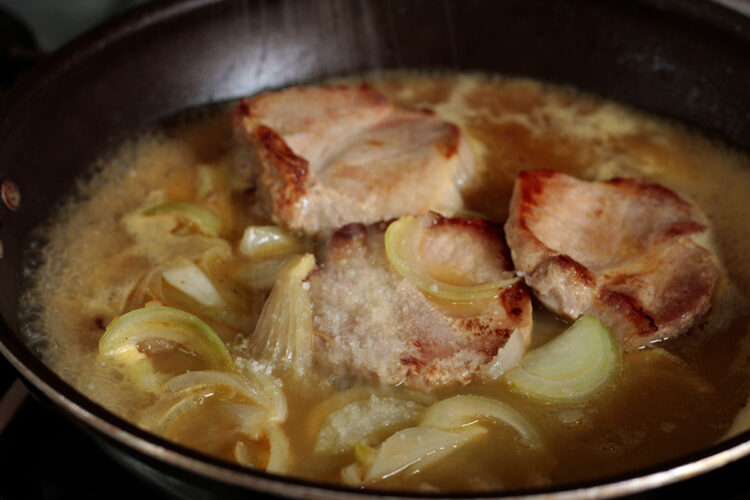 Seasoning pork chops in pan