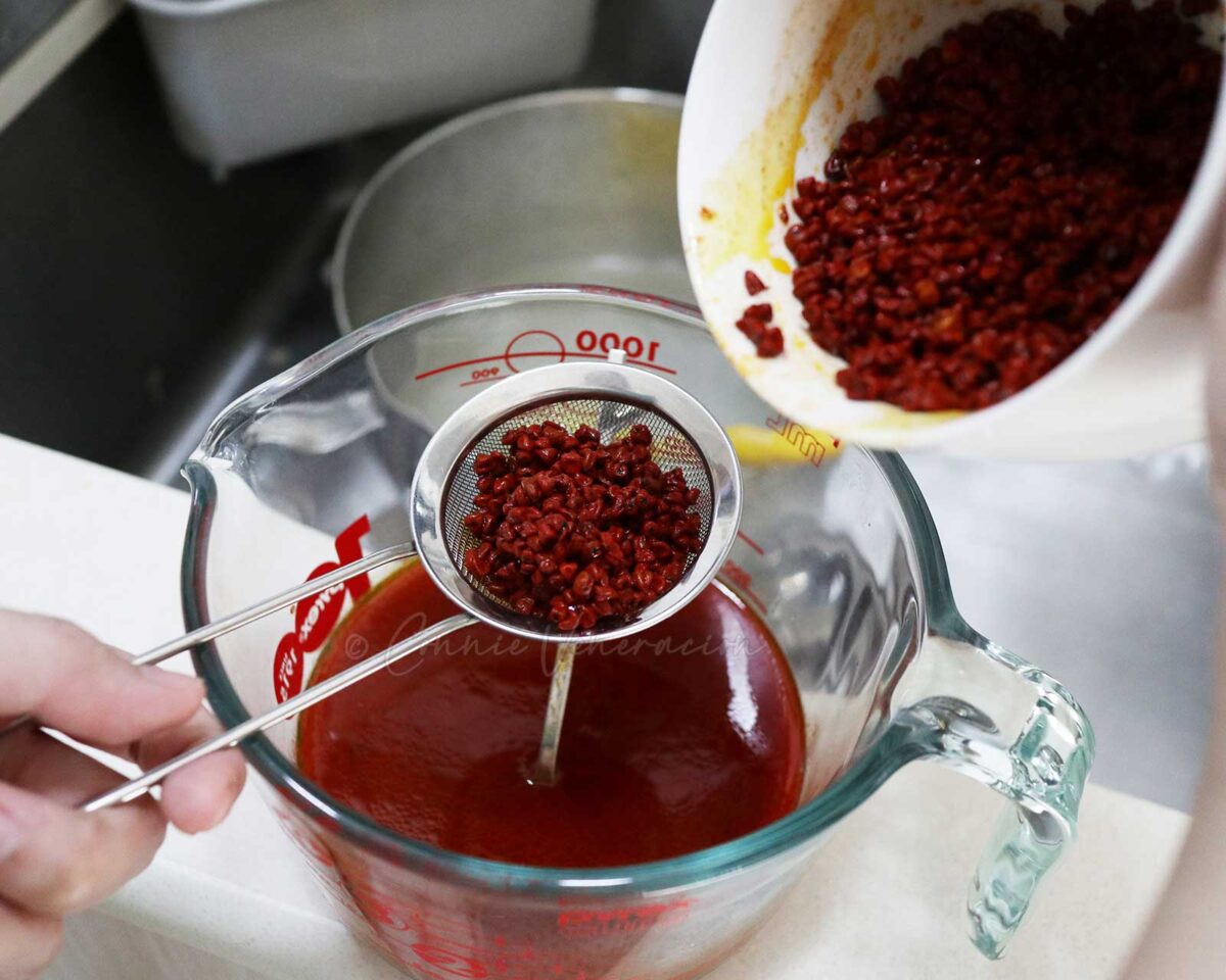 Straining soaked annatto seeds