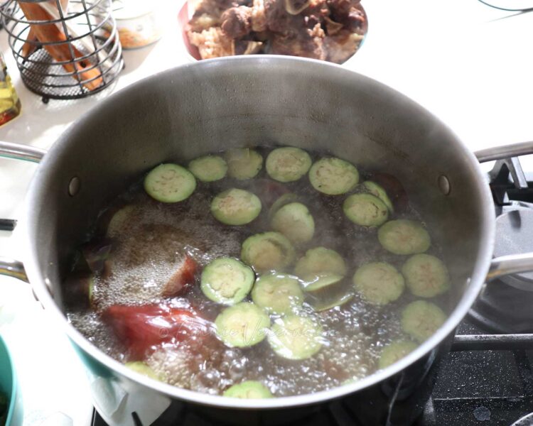 Sliced eggplants simmering in bone broth