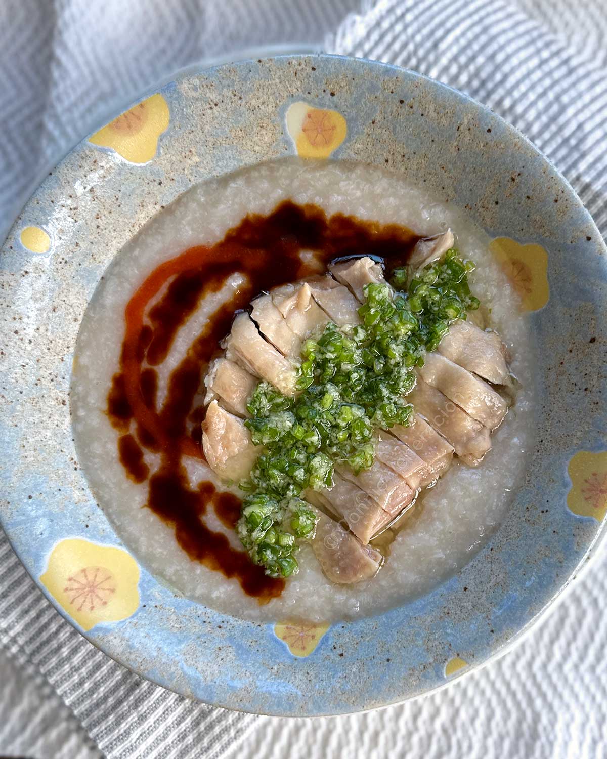 Hainese chicken congee with ginger-scallion sauce, sweet soy sauce and chili sauce